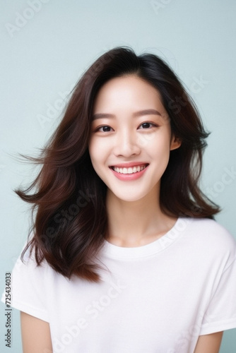 Young happy smiling Asian woman model wearing tshirt looking at camera on color background. Face skin hair care korean cosmetic and makeup, fashion ads. Beauty portrait. White t-shirt mock up template