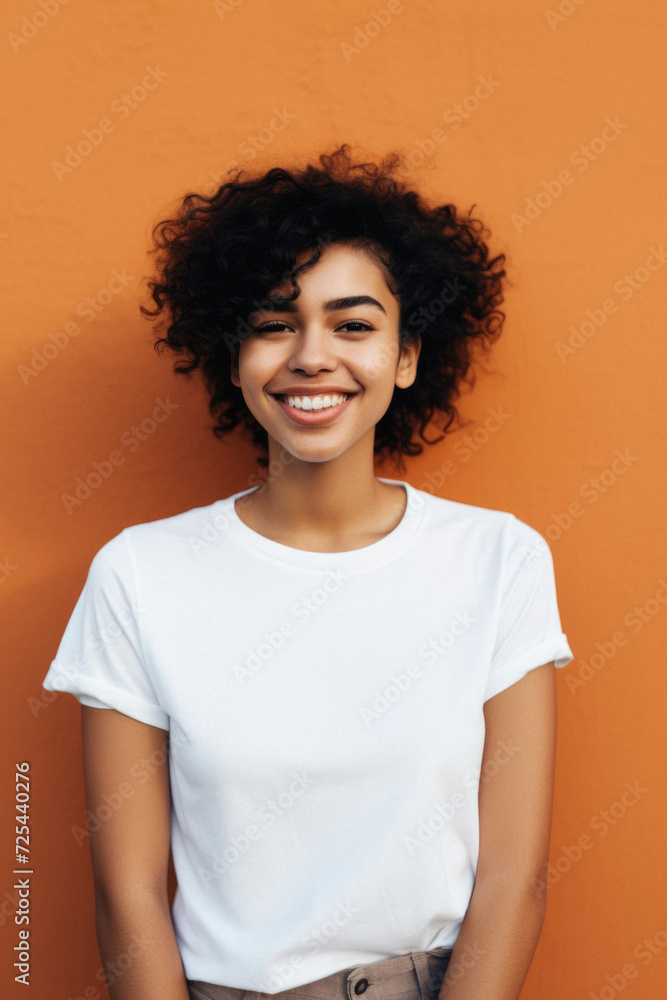 Young happy smiling Latin woman model wearing tshirt standing on color background. Face skin treatment, curly hair care cosmetics makeup, fashion ads. Beauty portrait. White t-shirt mock up template . Young happy smiling Latin woman model wearing tshirt standing on color background. Face skin treatment, curly hair care cosmetics makeup, fashion ads. Beauty portrait. White t-shirt mock up template .