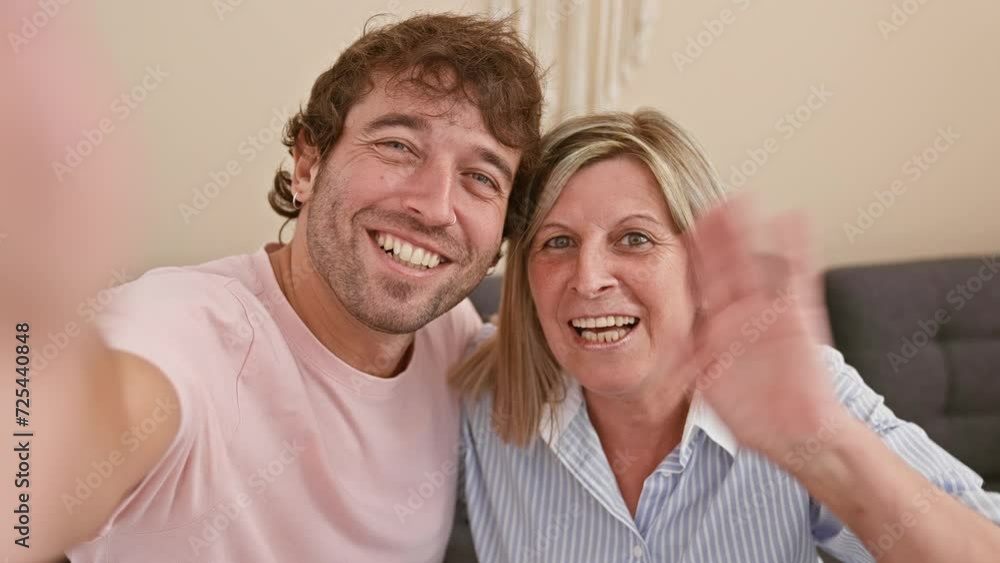 Happy mother and son enjoy fun video call together from their living room sofa, building a lovely indoor family relationship Happy mother and son enjoy fun video call together from their living room sofa, building a lovely indoor family relationship