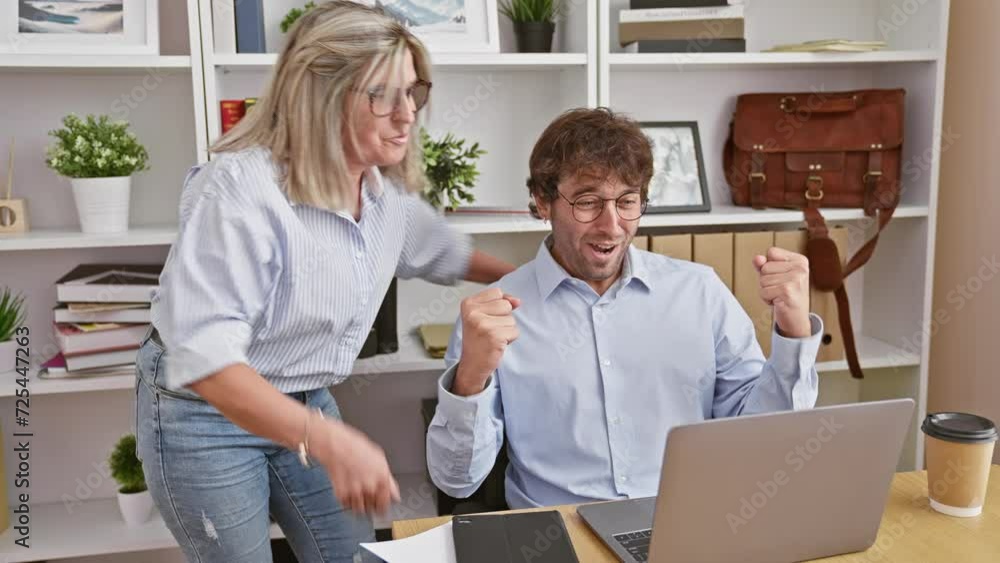 Celebrating win at work, two business partners, man and woman, toast success together over laptop screen in office. Celebrating win at work, two business partners, man and woman, toast success together over laptop screen in office.