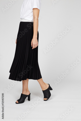 Black women's luxury Classic Long Maxi pleated skirt on model isolated on white background. Woman wearing Midi folded Accordion Skirt, summer autumn outfit. Side view. Template, concept