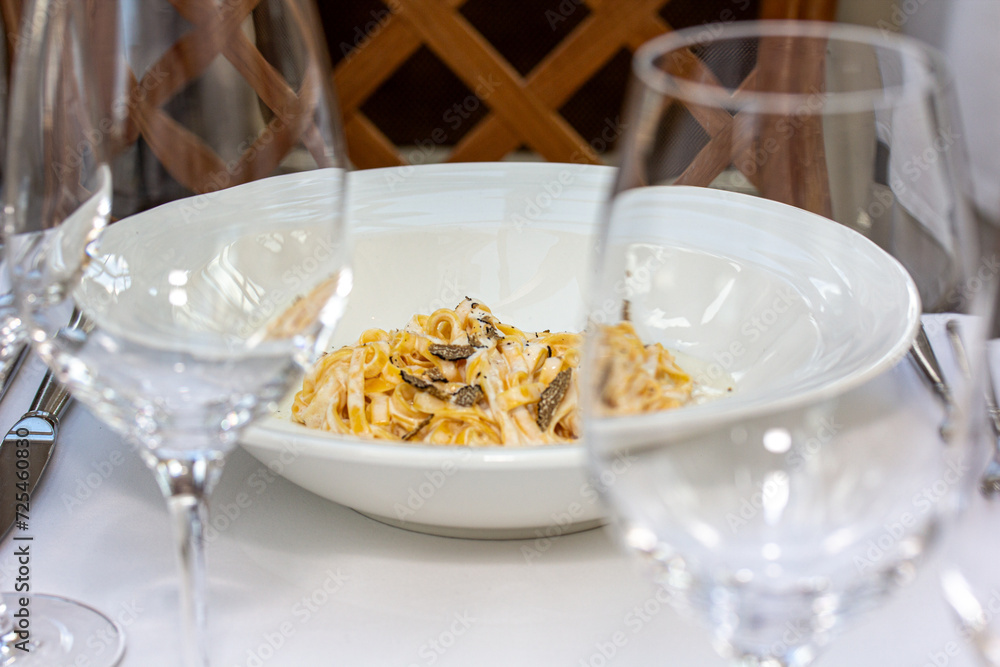 Spaghetti carbonara with mussels in white plate on the table Spaghetti carbonara with mussels in white plate on the table