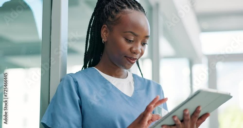 Nurse, typing on tablet and hospital or clinic research, online planning and telehealth software for test results. Happy doctor or woman on digital technology for medical service healthcare report photo