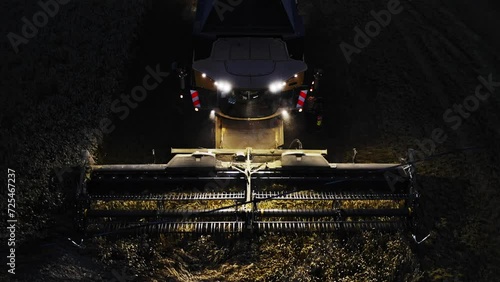 Combine harvester working at night with lights on