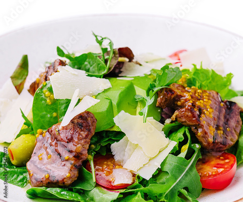 Green salad with beef, arugula and cherry tomatoes photo