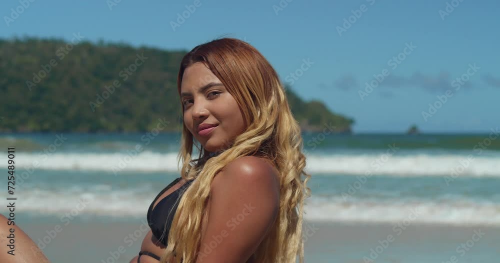 Amidst a tropical paradise, a young woman in a bikini savors the allure of a Caribbean beach with white sand with ocean waves in the background Amidst a tropical paradise, a young woman in a bikini savors the allure of a Caribbean beach with white sand with ocean waves in the background