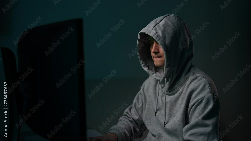 Hacker man in gray hoodie typing on keyboard, preparing to break password, drinking coffee. Programmer male writing code, virus program for cyber attack using computer, drinking beverage in dark room. Hacker man in gray hoodie typing on keyboard, preparing to break password, drinking coffee. Programmer male writing code, virus program for cyber attack using computer, drinking beverage in dark room.