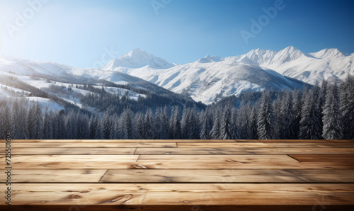 Wooden surface foreground with a magical winter landscape background, snow covered pine trees, and majestic snow capped mountains under a clear blue sky