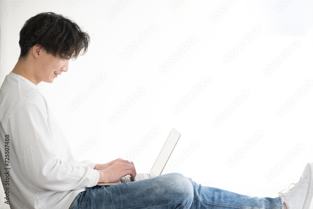 Image of a handsome Asian (Japanese) man sitting and typing on a computer. Image of a handsome Asian (Japanese) man sitting and typing on a computer.