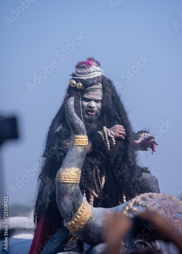 Masan Holi, Portrait of an male artist act as lord shiv with dry ash on face and body also in air while celebrating the masan holi as tradition at Harishchandra ghat in varanasi.
