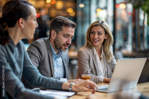 Business Meeting: Group of People Working on Laptops at Table.