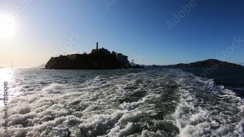 Sailing at Alcatraz prison island in San Francisco, California, USA at sunset with view of Golden Gate bridge at background