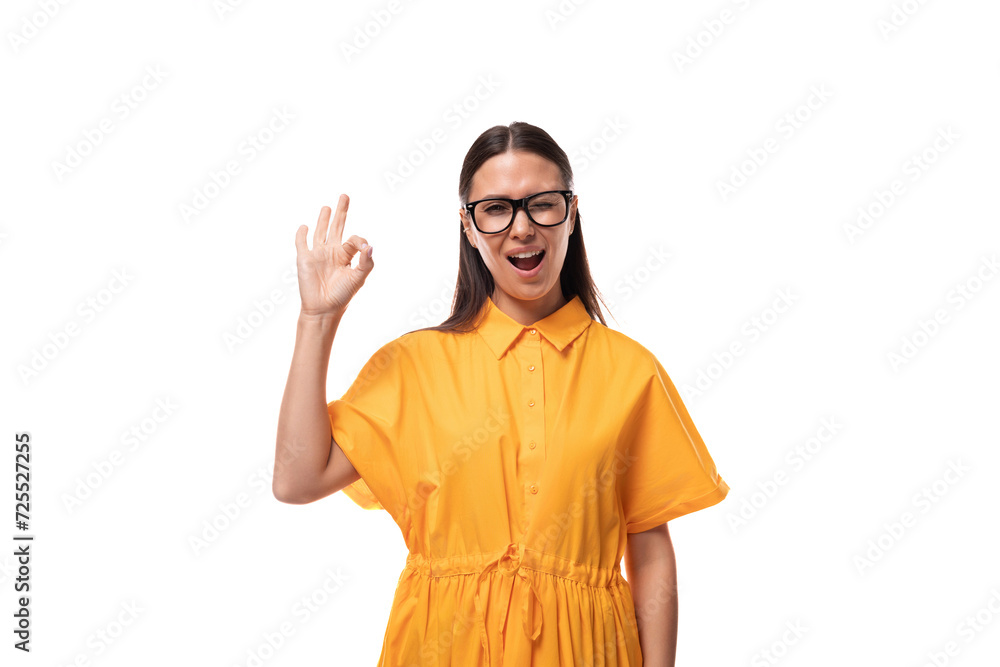 young black-haired woman with glasses dressed in an orange summer dress shows a gesture of class young black-haired woman with glasses dressed in an orange summer dress shows a gesture of class