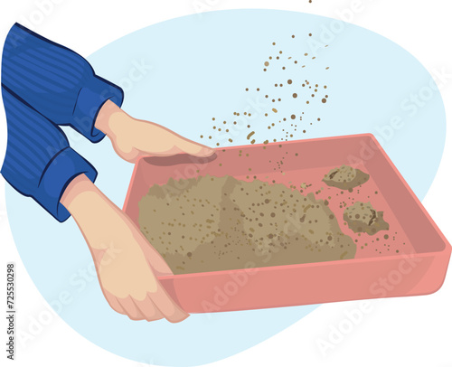 Cat litter box. human hand shaking the cat's sand before cleaning it up.