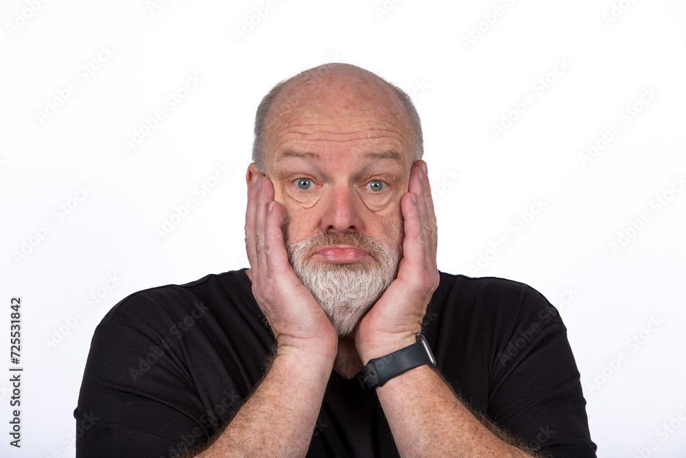 Stressed Middle-Aged Man in Black T-Shirt Expressing Shock and Despair on White Background Stressed Middle-Aged Man in Black T-Shirt Expressing Shock and Despair on White Background