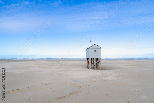 A wooden shelter on high stilts that stands on the North Sea beach (De Drenkelingenhuisje) The Dutch Wadden Sea island Terschelling, Municipality and an island in the northern, Friesland, Netherlands. photo