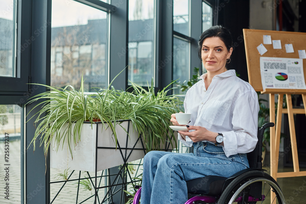 jolly beautiful disabled woman in business attire in wheelchair holding coffee and smiling at camera jolly beautiful disabled woman in business attire in wheelchair holding coffee and smiling at camera