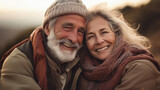Portrait of happy senior couple in winter clothes smiling at camera outdoors