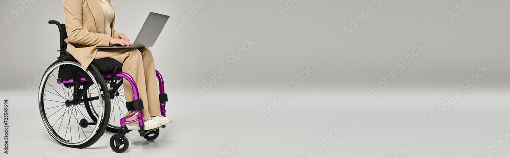 cropped view of woman with disability in pastel suit in wheelchair working on laptop, banner cropped view of woman with disability in pastel suit in wheelchair working on laptop, banner