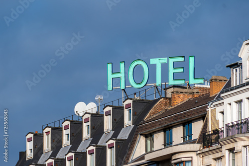 Enseigne avec le mot 'HOTEL' écrit en lettres capitales lumineuses sur le haut d'un immeuble à Paris, France photo