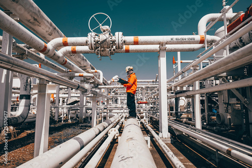 Top view male worker inspection at steel long pipes and pipe elbow in station oil factory during refinery valve of visual check record pipeline oil and gas