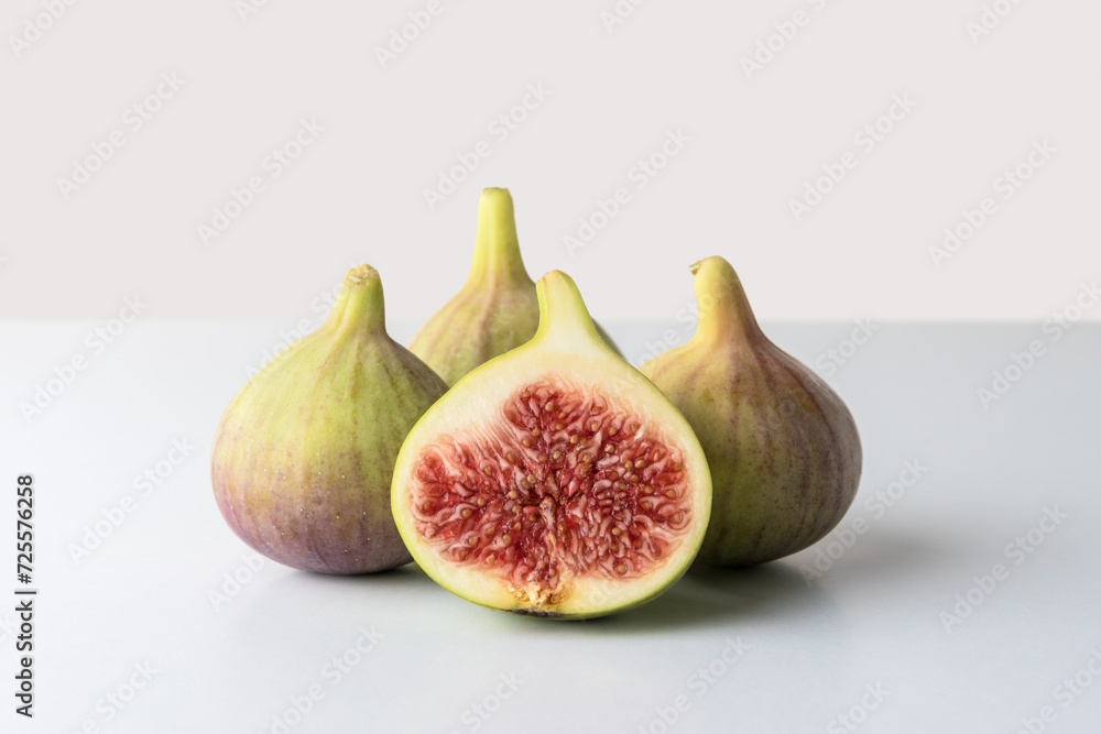 Composition with whole and cut figs on gray background. Food concept. Composition with whole and cut figs on gray background. Food concept.