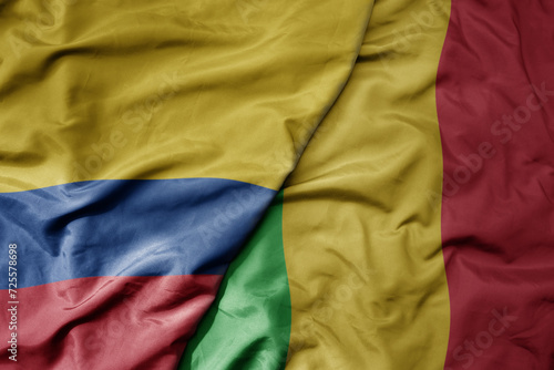 big waving national colorful flag of mali and national flag of colombia .