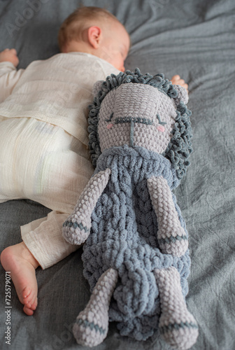 Little baby boy with toy in bed, handmade pajama bag, sleepwear organizer