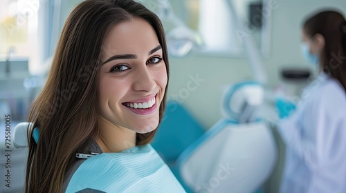 A beautiful young woman is smiling sitting in the dentist's chair.