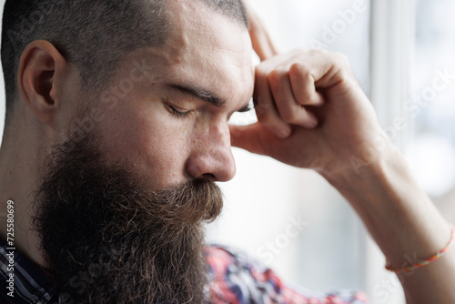 Brutal man with emotion of disappointment and depression on gray background. 