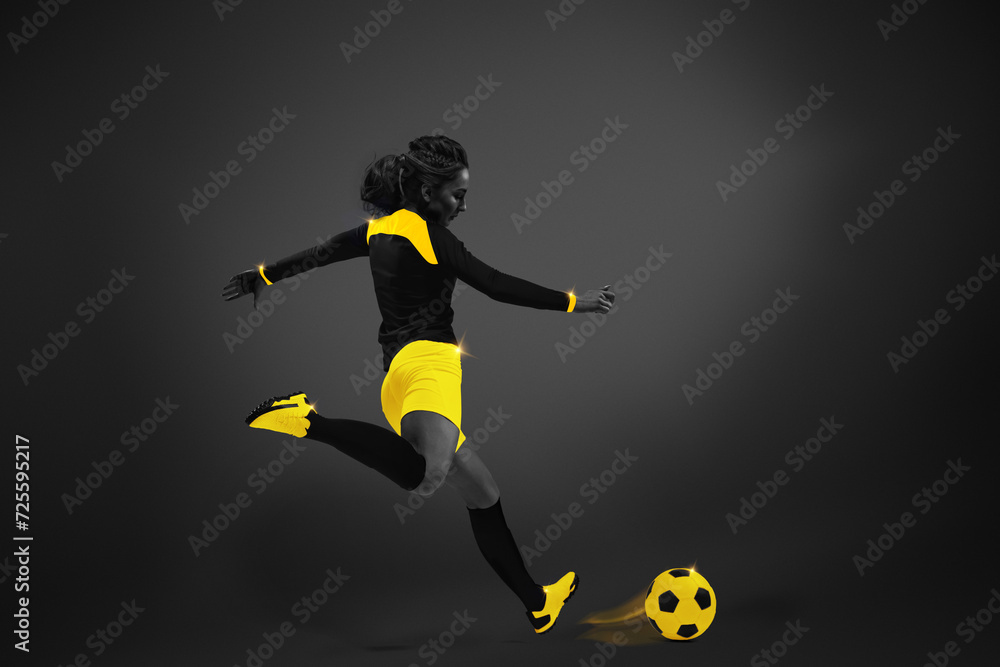 Young girl, soccer player in motion with ball, playing over dark background. Yellow elements. Monochrome. Concept of competition, tournament, match, game. Creative design.