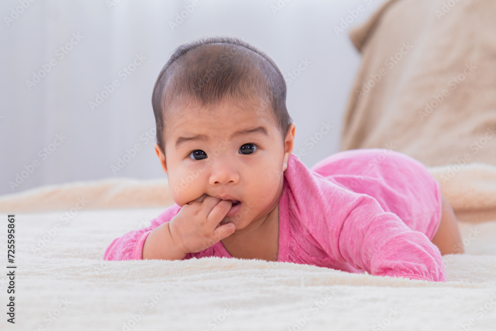 Closeup shot of toddler newborn baby wearing bodysuit leisure soft touch comfortable lying down alone on bed and looking camera at home, healthcare and pediatrics. Baby health care products concept. Closeup shot of toddler newborn baby wearing bodysuit leisure soft touch comfortable lying down alone on bed and looking camera at home, healthcare and pediatrics. Baby health care products concept.