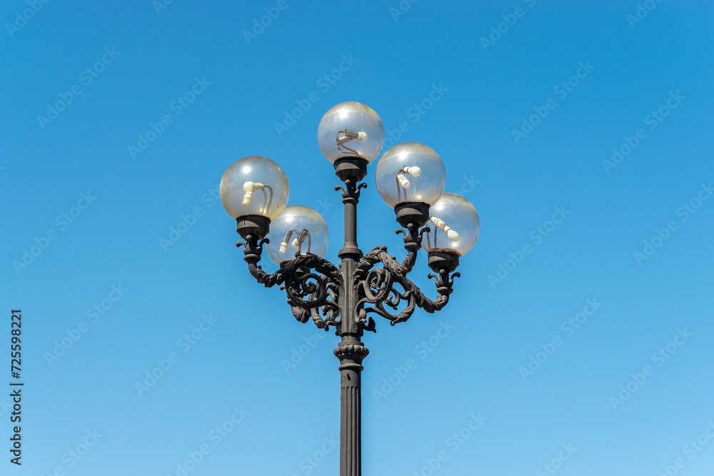 Old lamppost on street with blue sky background. Old lamppost on street with blue sky background.