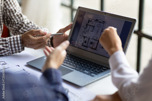 Group of architects meet together to design a map for the construction of a parking building project. Team of modern architects working on laptop in office.