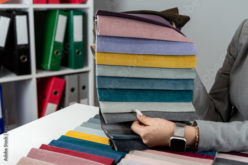 Woman designer choose at tissue samples best bright color for a new furniture at home