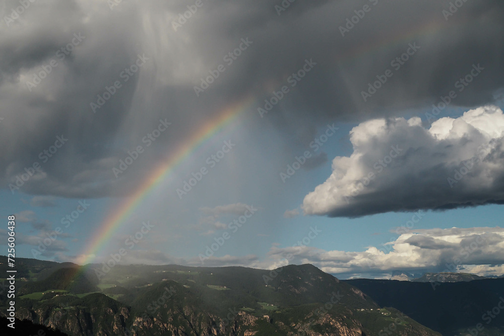 Regenbogen an einem wolkigen Himmel in den Bergen von Südtirol