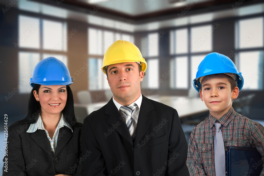 Two engineers and a child with protective helmets Two engineers and a child with protective helmets