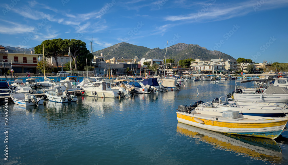 Nea Makri harbour, Attica Greece. Fishing boat moored in Aegean calm sea. Greek sun and blue sky.