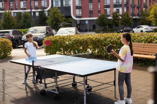 Little children playing ping pong in park © Angelov