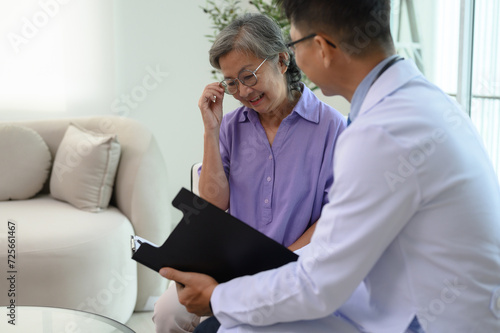 Male doctor giving advice to senior female patient in examination room