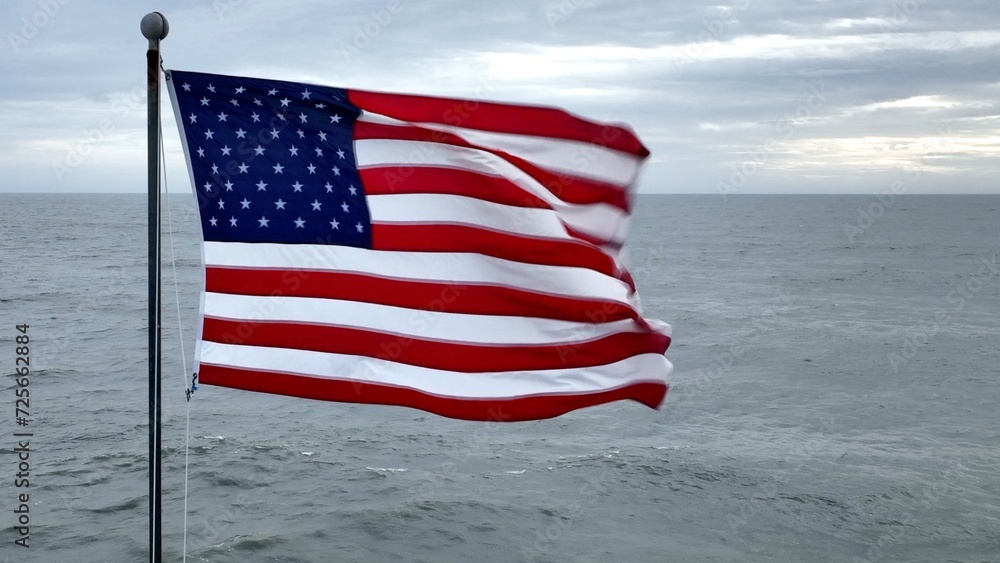 American flag blowing in the wind with ocean in background in coastal South Carolina