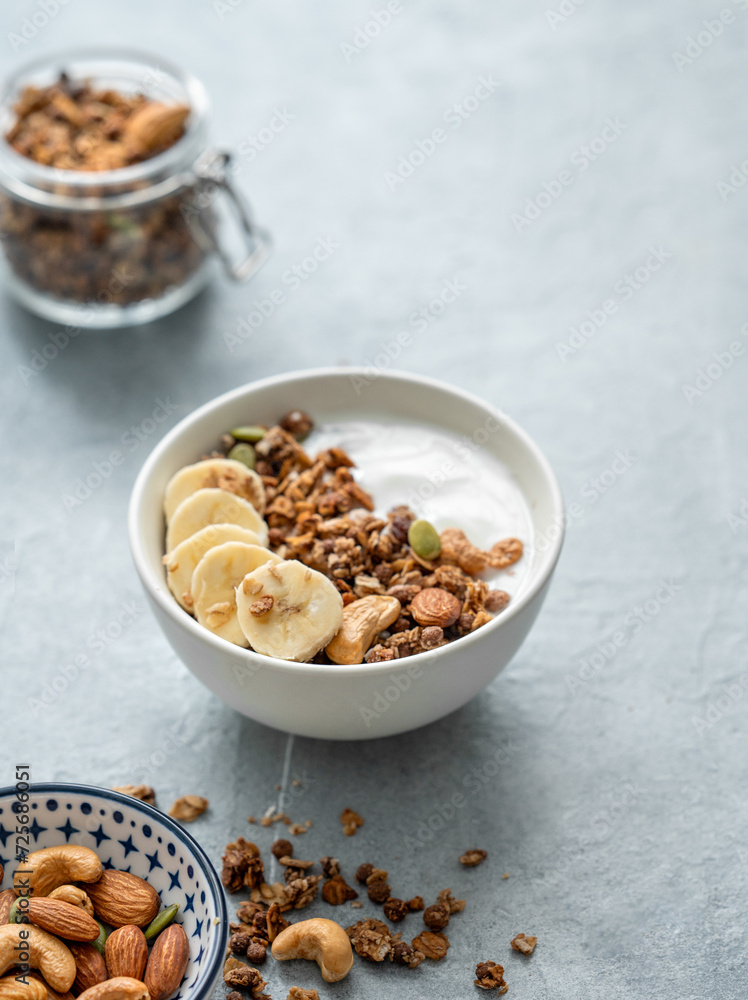 Granola or muesli with yogurt and banana on a light table. Granola or muesli with yogurt and banana on a light table.