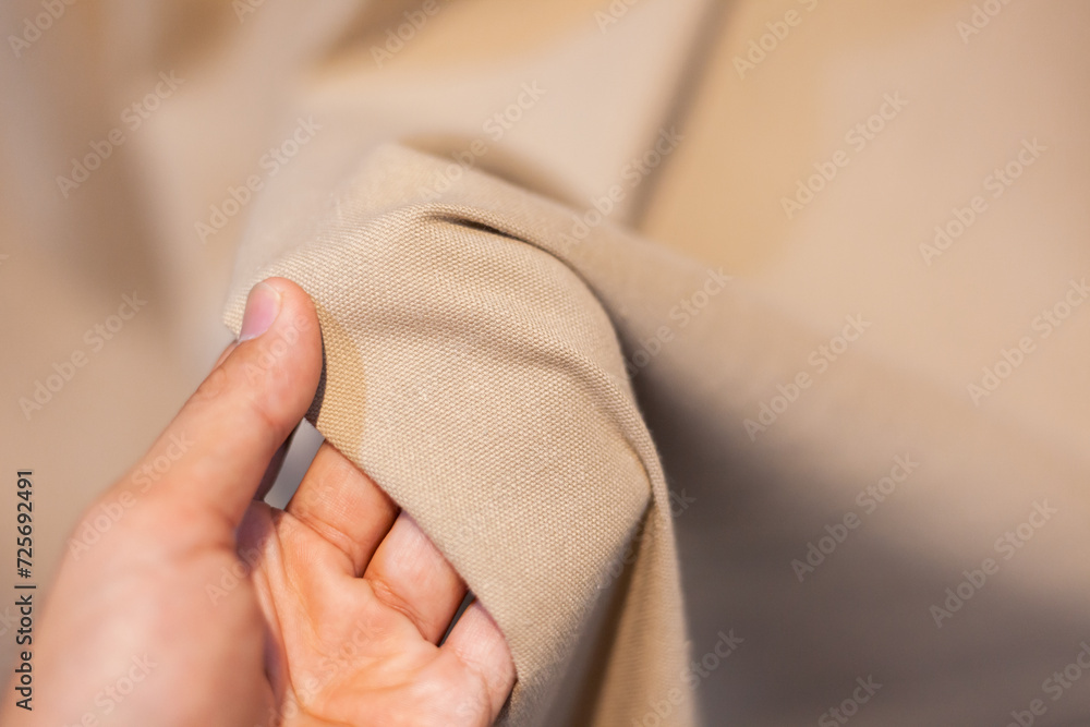 Hand Soft touch natural fabric. The hand is holding the white cloth for choosing a good fabric. Hand Soft touch natural fabric. The hand is holding the white cloth for choosing a good fabric.
