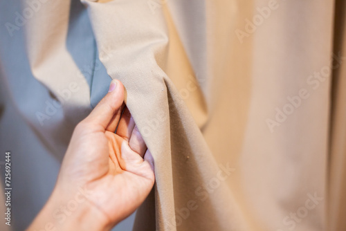 Hand Soft touch natural fabric. The hand is holding the white cloth for choosing a good fabric.