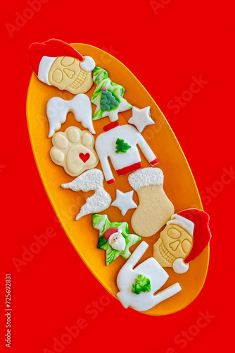 Weihnachtskekse mit verschiedene Motive auf einen Teller vor einem roten Hintergrund