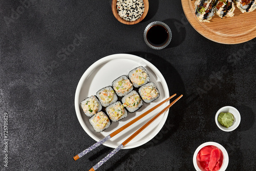 Assorted Sushi Rolls with Shrimp Tartare, Avocado, and Tobiko Caviar on a Modern Dark Surface