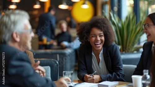 Meeting business  Diverse group of businesspeople laughing together while having a meeting in the lounge of office.