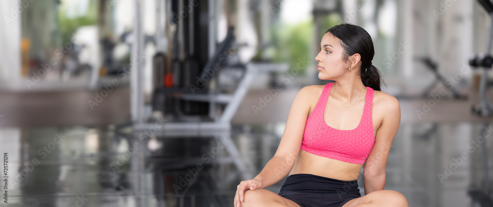 A young woman takes a mindful moment in her gym routine.. A young woman takes a mindful moment in her gym routine..