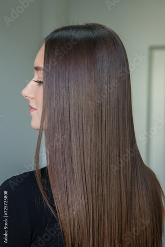 Portrait of a beautiful woman with long brown straight hair in a beauty salon.
