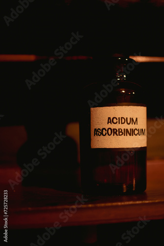 A bottle of Acidum Ascorbinicum on a shelf in darkness photo